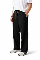 Person wearing black pants with a white shirt on a white background