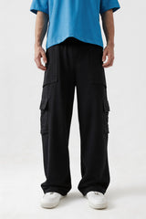 Person wearing black cargo pants and a blue shirt on a white background